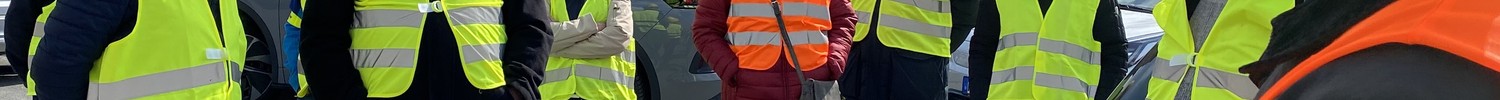 Mehrere Personen in Warnwesten stehen vor einem Brachgelände. (Bild: LWL/SchuFi)