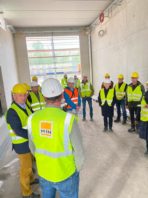 Ein Gruppe von Menschen in Bau-Schutzkleidung steht in einem langen, hohen Raum mit großer Öffnung nach draußen. (Bild: LWL/Schufi) (vergrößerte Bildansicht wird geöffnet)